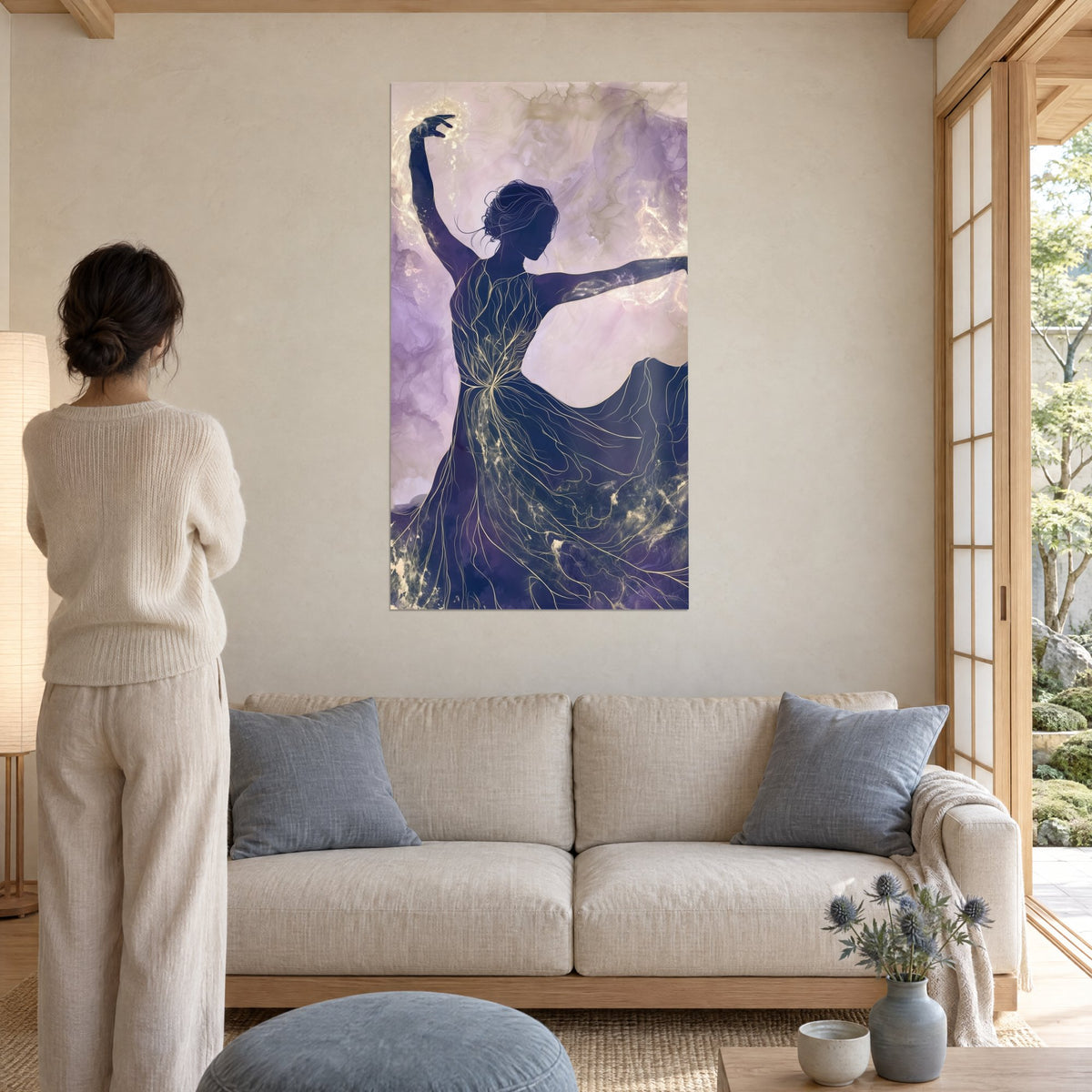 Cuadro bailarina en silueta violeta, brazo en alto y vestido con nervaduras doradas, fondo lila, sobre un sofá en un salón luminoso