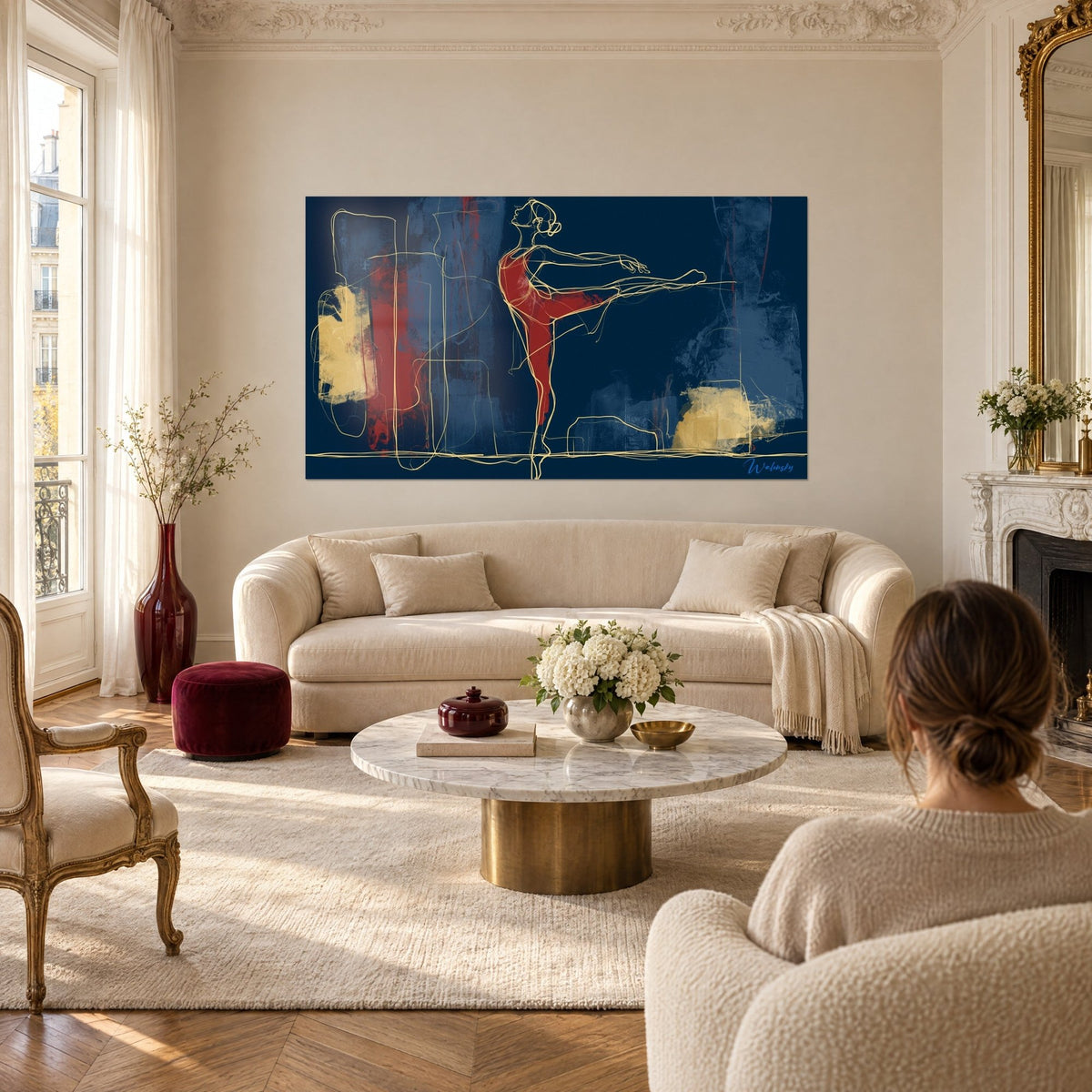 Tableau danseuse au trait doré, jambe levée, rouge carmin sur fond bleu marine, au-dessus d'un canapé dans un salon lumineux