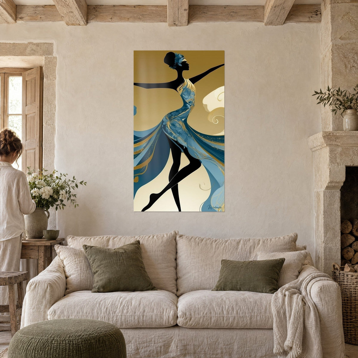 Tableau danseuse en silhouette noire, robe bleue et dorée à volutes fluides, fond ocre, au-dessus d'un canapé dans un salon lumineux
