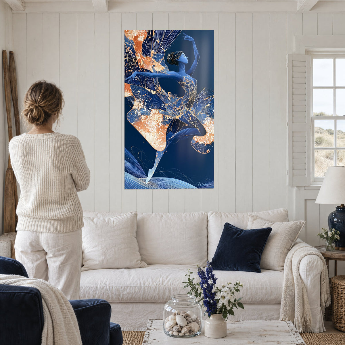 Tableau danseuse bleu cobalt en arabesque, voile cuivré nervuré, chignon de profil, au-dessus d'un canapé dans un salon lumineux