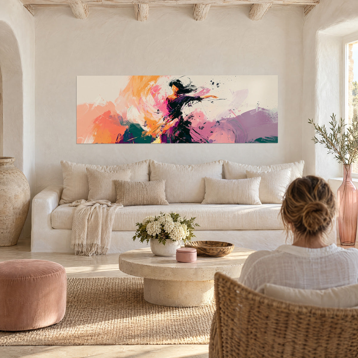 Wall art of a dancer with flowing black hair and a crimson veil with orange highlights, hanging above a sofa in a bright living room