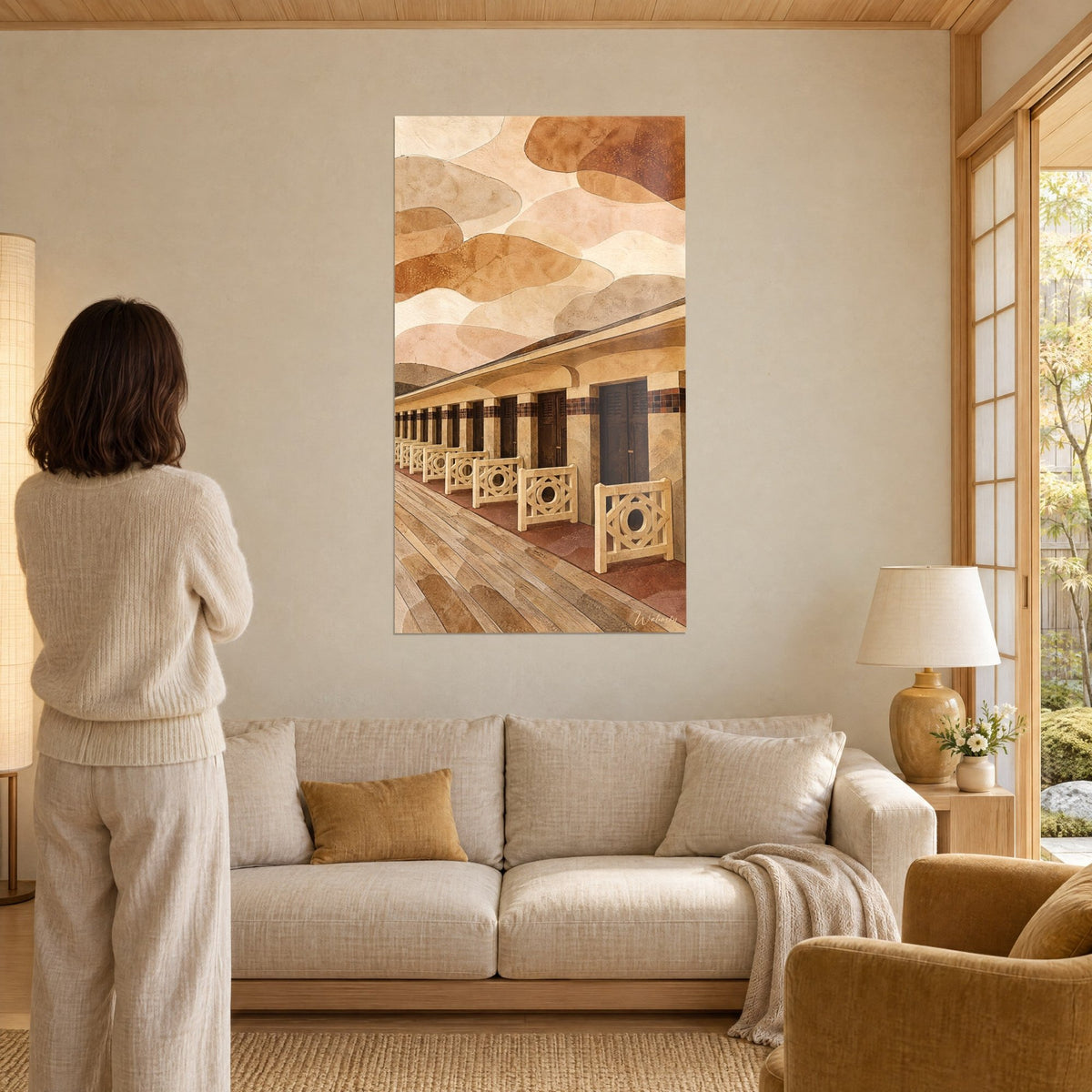 Tableau cabines de plage en ocre et beige, balustrades losanges, ciel de nuages roux, au-dessus d'un canapé dans un salon lumineux