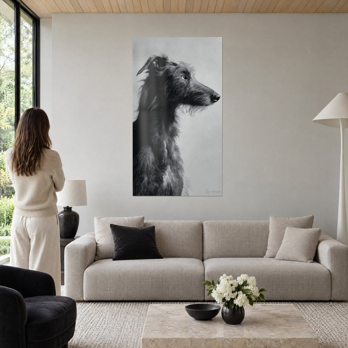 Tableau lévrier deerhound de profil, pelage anthracite hirsute sur fond gris perle, au-dessus d'un canapé dans un salon lumineux