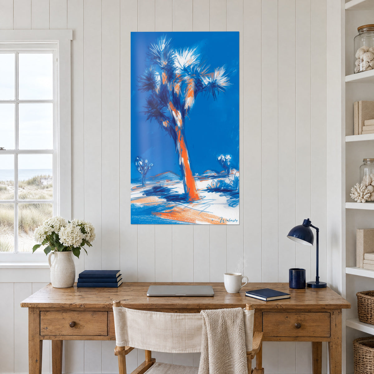 Wall art desert tree with ruffled midnight blue and white leaves, orange trunk, wooden desk, seaside house
