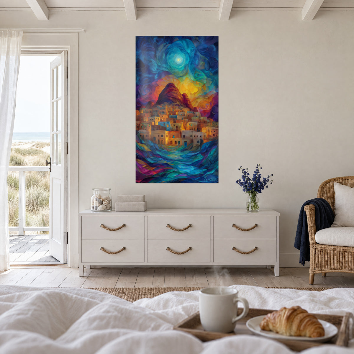 Wall art of an illuminated adobe town under an indigo and gold starry sky, in front of an open door, above a bed in a bright bedroom
