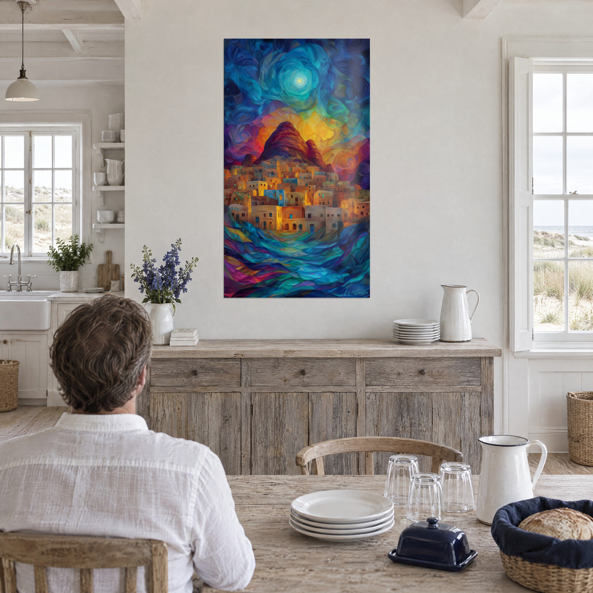 Wall art of stacked ochre dwellings under a cyan moon halo, purple and green waves, above a seaside kitchen table