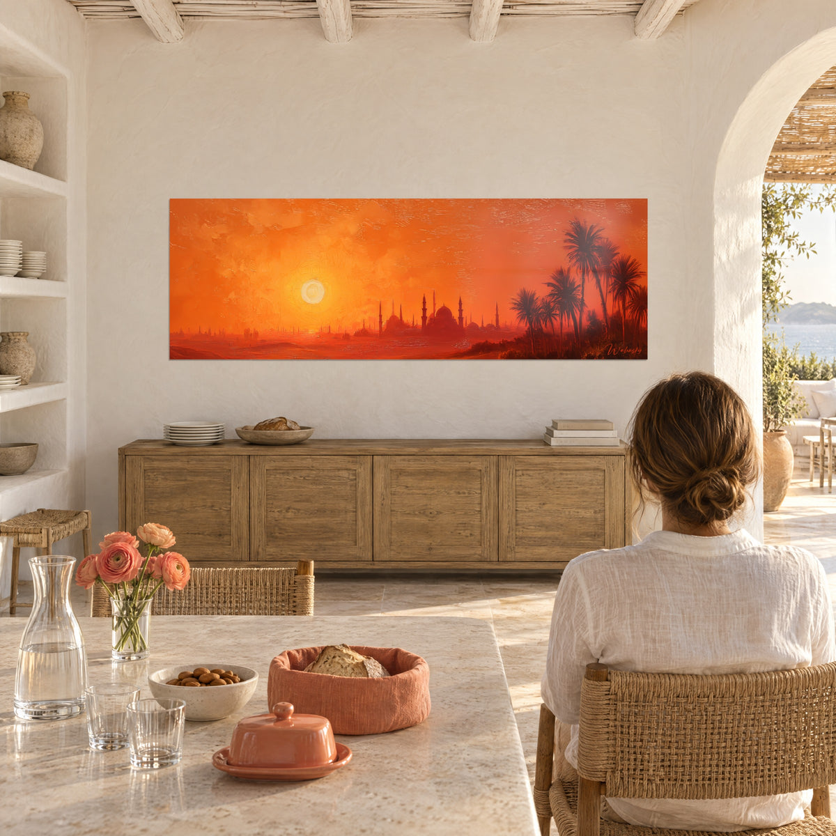 Cuadro cúpulas y minaretes recortados sobre un cielo color azafrán, palmas a contraluz, colgado en una cocina blanca con un ramo de tulipanes
