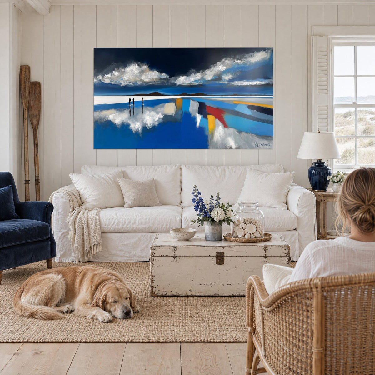 Gemälde Salzsee-Spiegelung unter weißen Wolken, kobaltblau und leuchtend rot, liegender Retriever, über einem Sofa in einem hellen Wohnzimmer