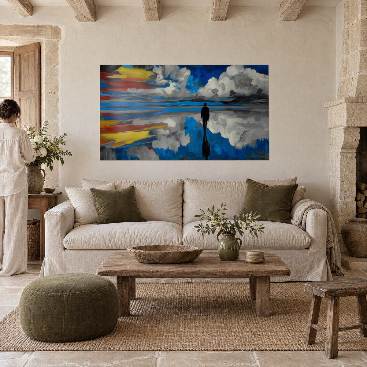 Wall art man in shadow silhouette on a mirror lake, cobalt blue sky with grey clouds and yellow streaks, above a sofa in a bright living room
