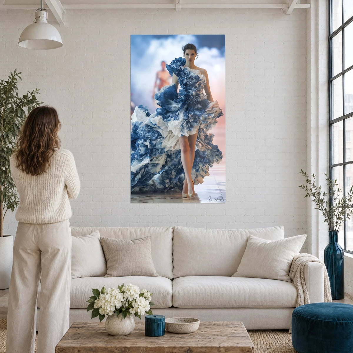 Tableau mannequin en robe de volants bleu cobalt et blanc crème, ciel nuageux, au-dessus d'un canapé dans un salon lumineux