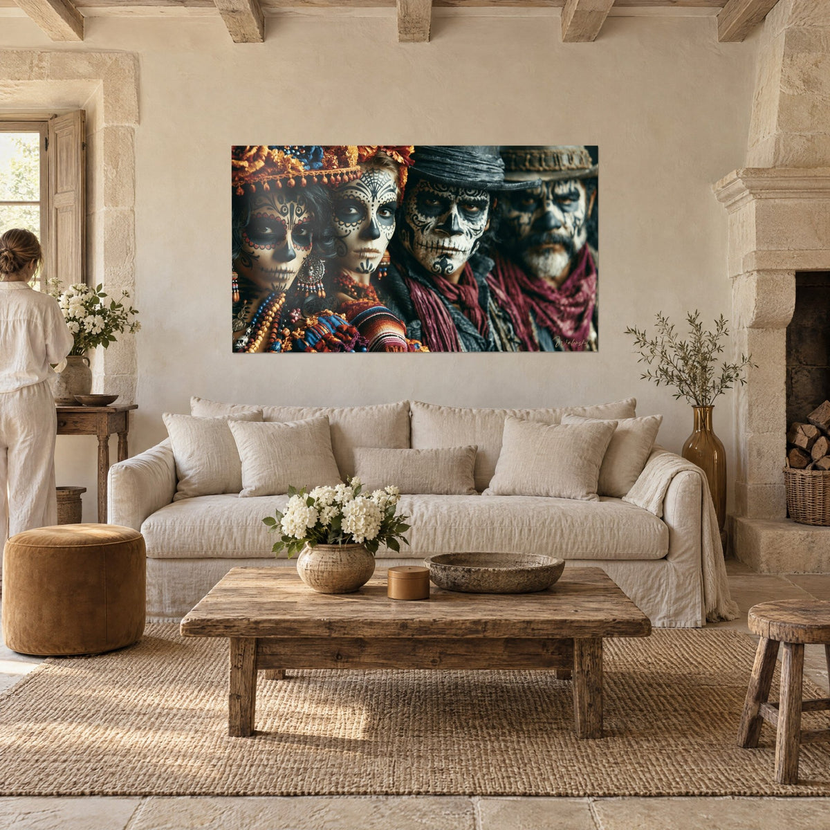 Tableau quatre visages peints en crânes noir et ivoire, écharpe bordeaux, perles colorées, au-dessus d'un canapé dans un salon lumineux
