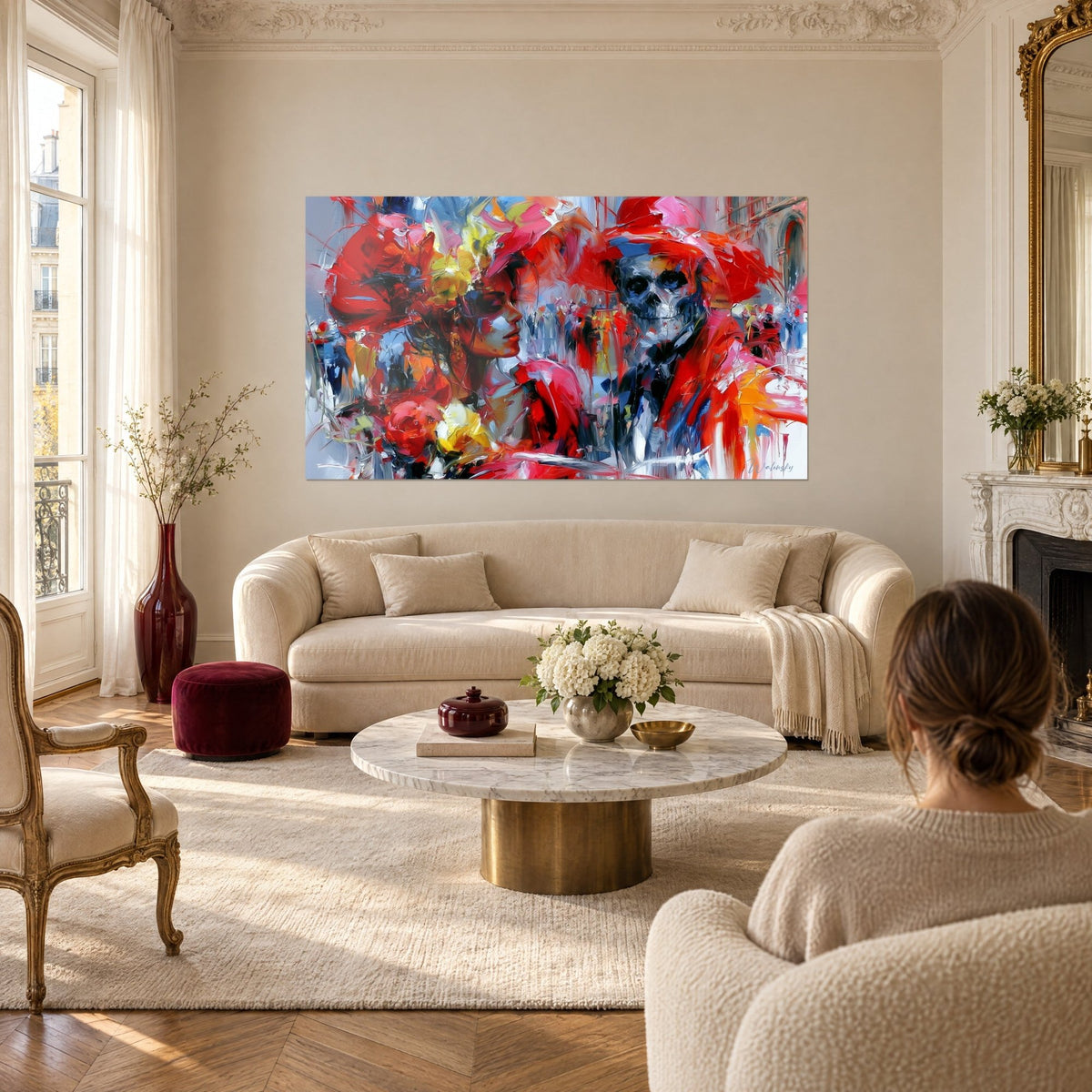 Quadro donna di profilo in rosso e corallo, scheletro blu notte con cappello scarlatto, sopra un divano in un soggiorno luminoso
