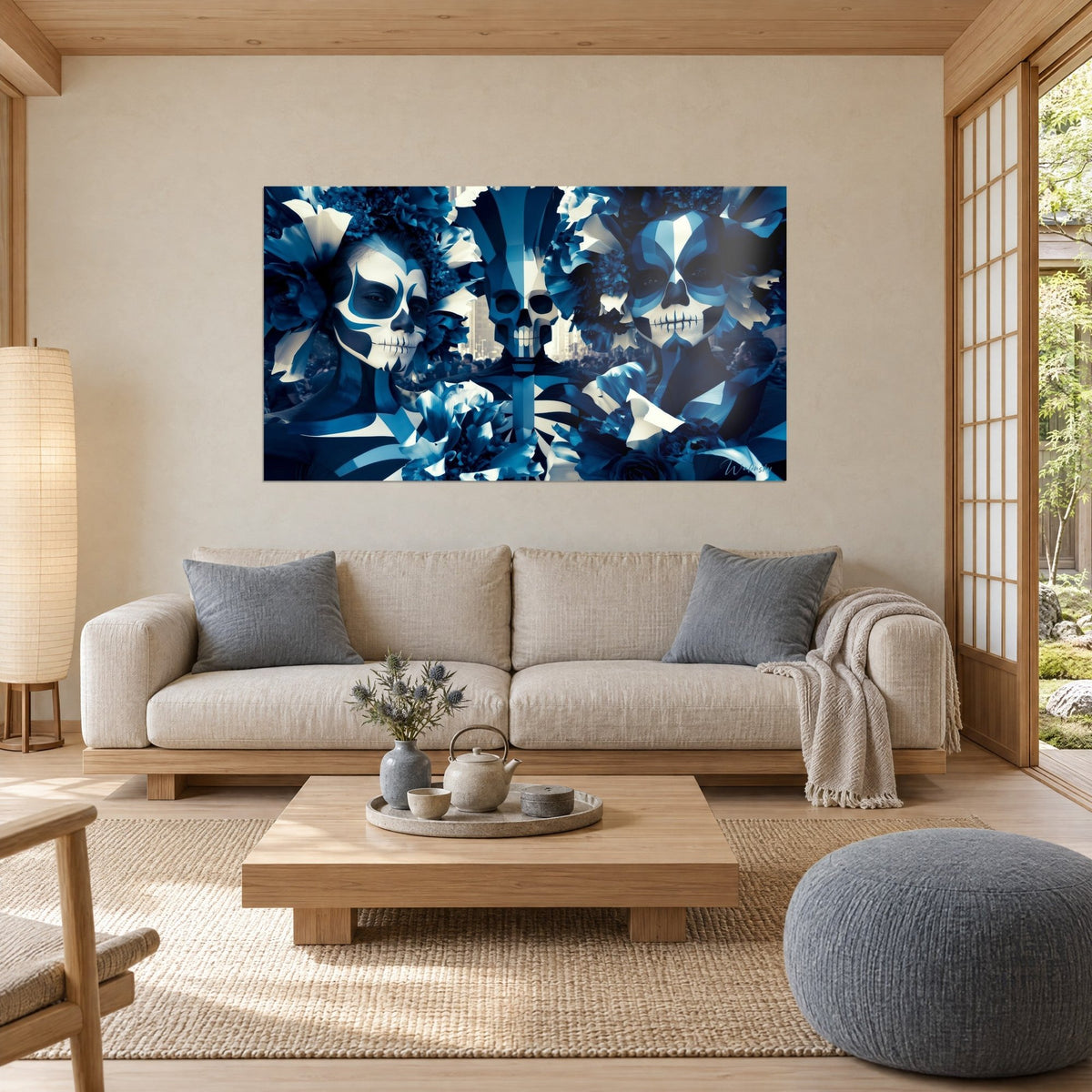 Tableau crâne de sucre aux motifs bleu et blanc entre deux visages peints, fleurs de papier, au-dessus d'un canapé dans un salon lumineux