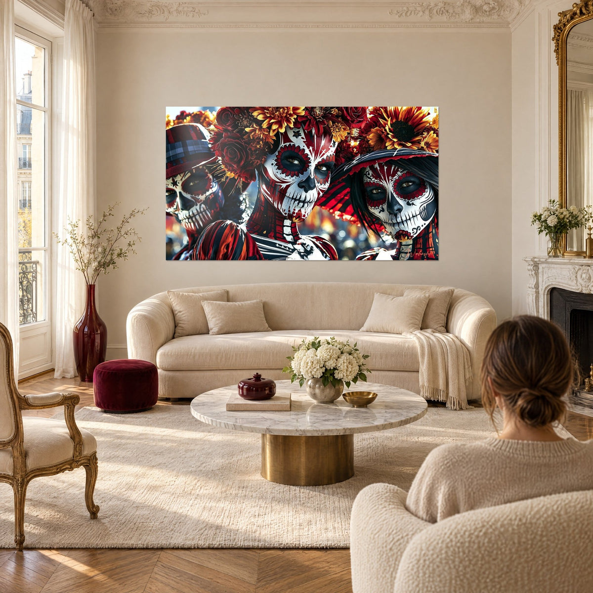 Tableau trois crânes de sucre maquillés en rouge et blanc sous couronnes de fleurs, au-dessus d'un canapé dans un salon lumineux
