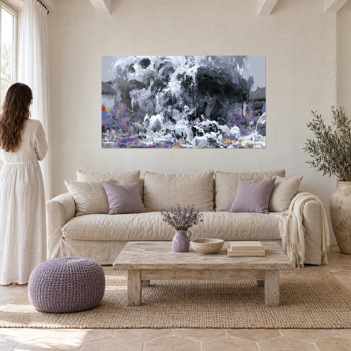 Gemälde Totenschädel-Gesicht, schwarzer Hut und weiße Spritzer auf grauem Grund, über einem Sofa in einem hellen Wohnzimmer