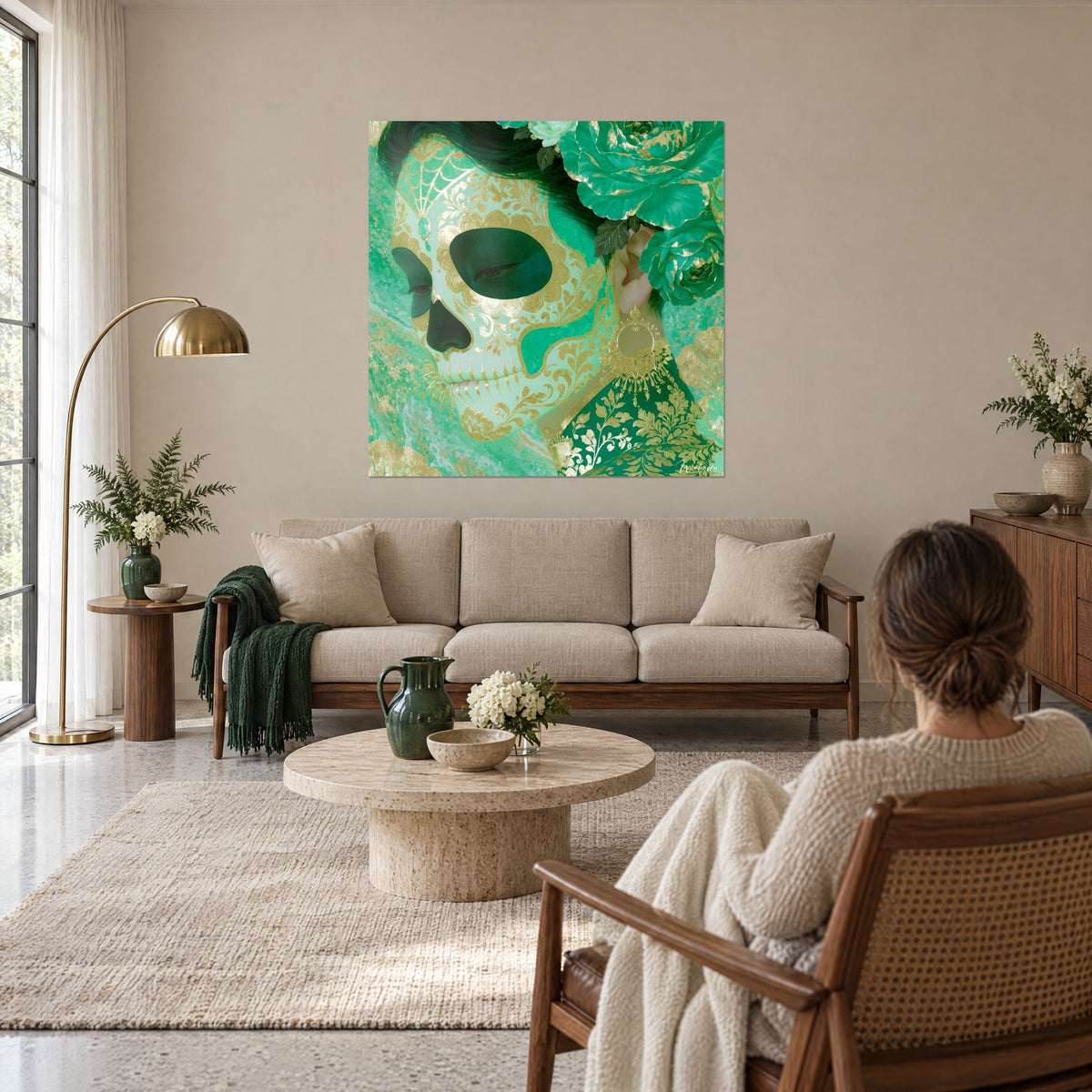 Gemälde Zuckerschädel in Smaragd mit goldenen Arabesken, Krone aus grünen Rosen, über einem Sofa in einem hellen Wohnzimmer