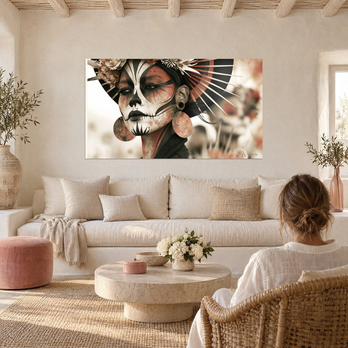 Gemälde Totenkopfgesicht in Weiß und Schwarz, terrakottafarbener Fächer, über einem Sofa in einem hellen Wohnzimmer