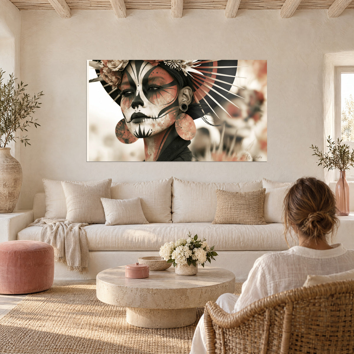 Wall art skull-painted face in white and black, terracotta fan, above a sofa in a bright living room