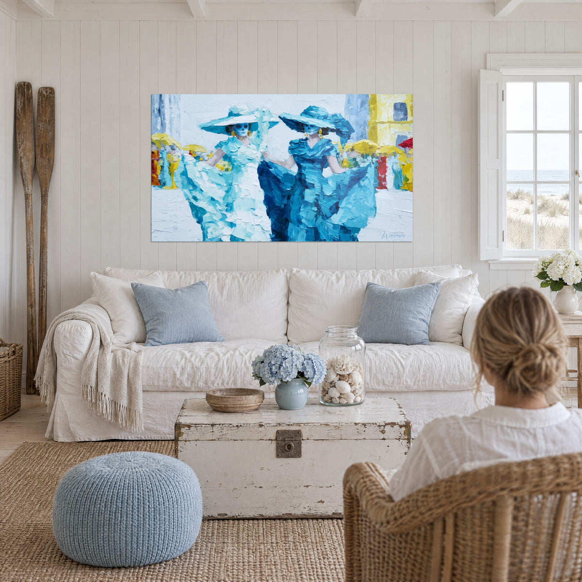 Tableau Catrinas masquées en robes bleu turquoise et blanches, ombrelles jaunes, au-dessus d'un canapé dans un salon lumineux