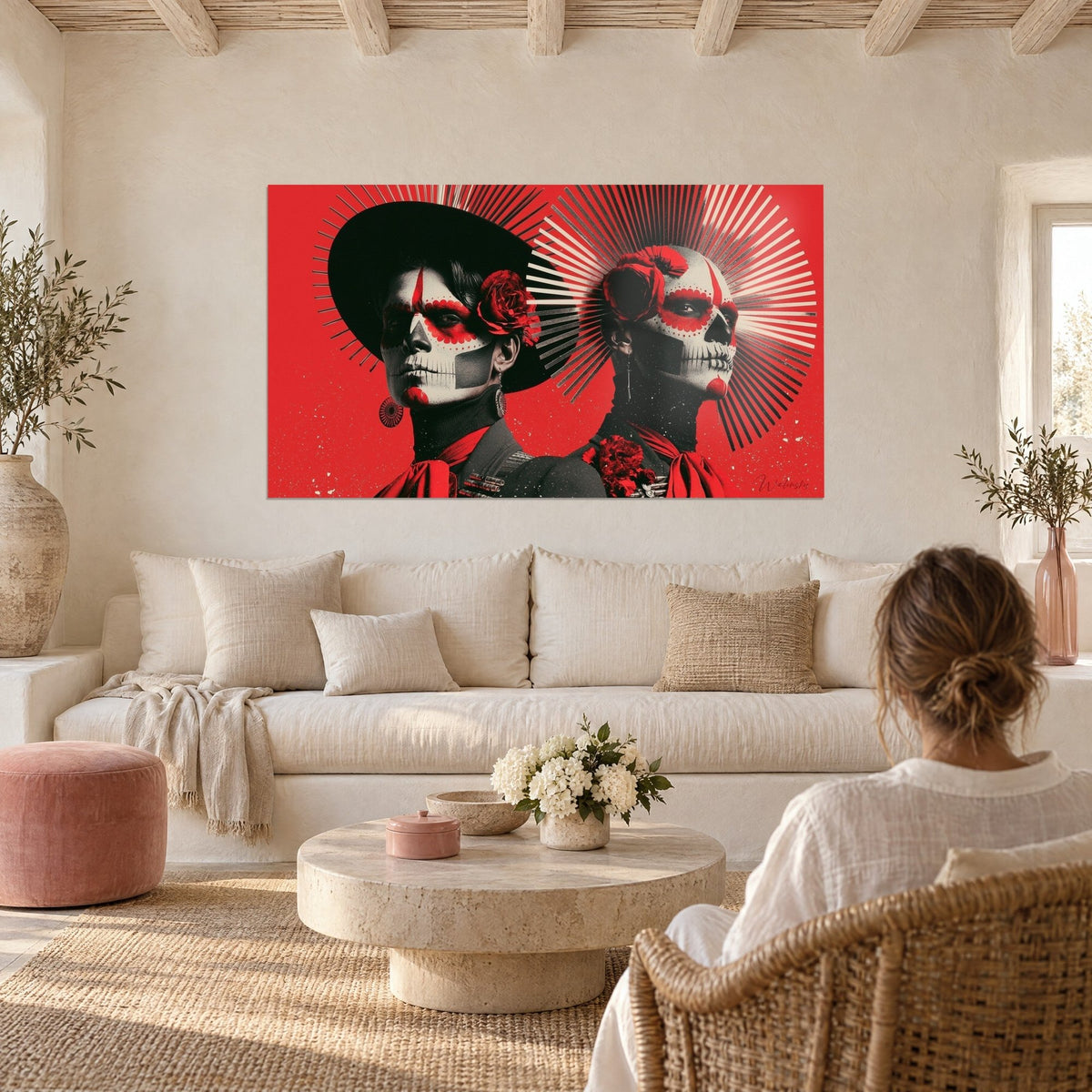 Tableau duo de visages peints en crâne, fond rouge vif et noir, rayons argentés, au-dessus d'un canapé dans un salon lumineux