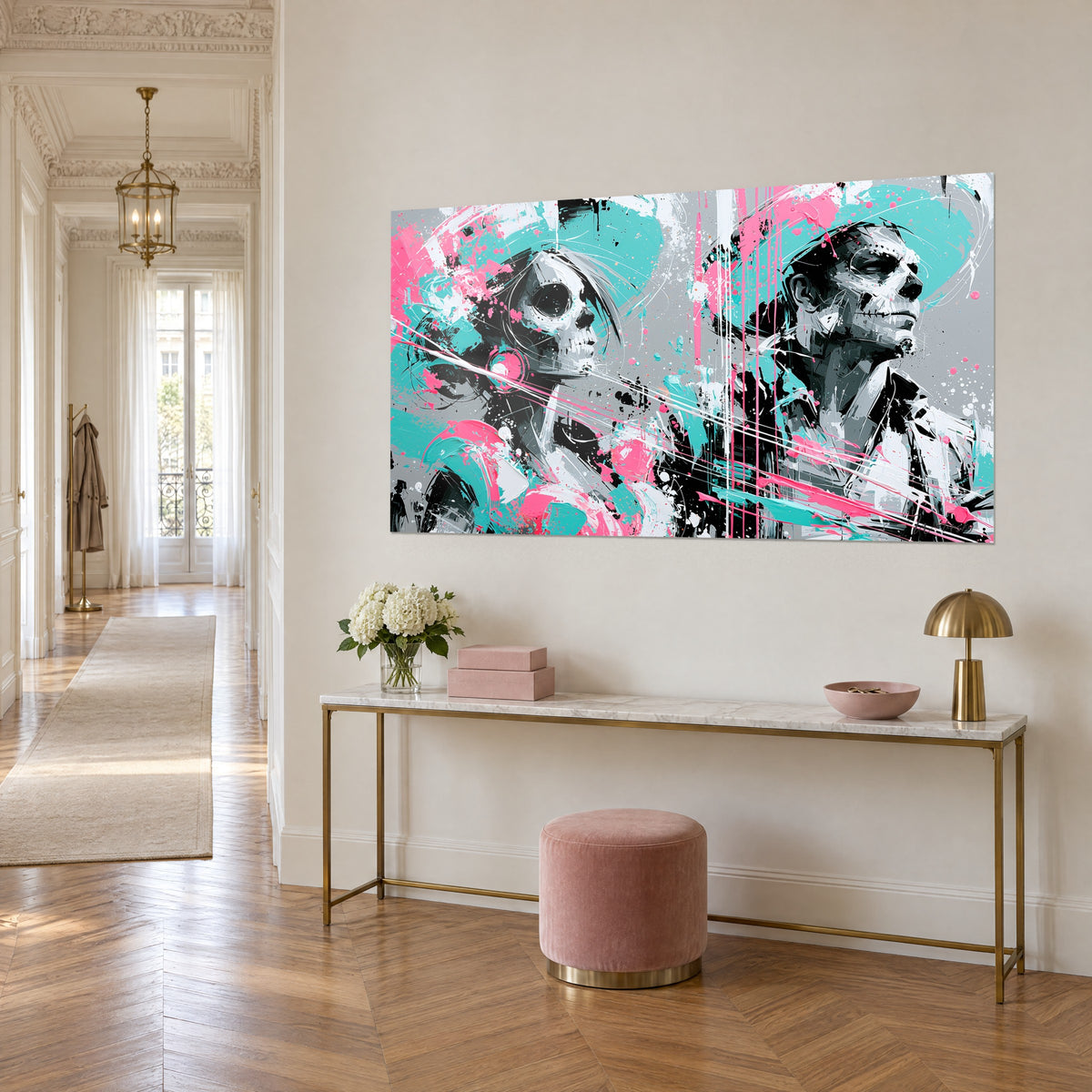 Wall art diptych of black and white skulls streaked with turquoise and vivid pink, viewed at an angle, above a gilded console table