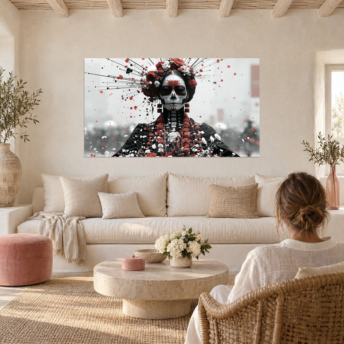 Quadro volto di catrina dipinto in nero e rosso, corona di rose, raggi esplosi, sopra un divano in un soggiorno luminoso