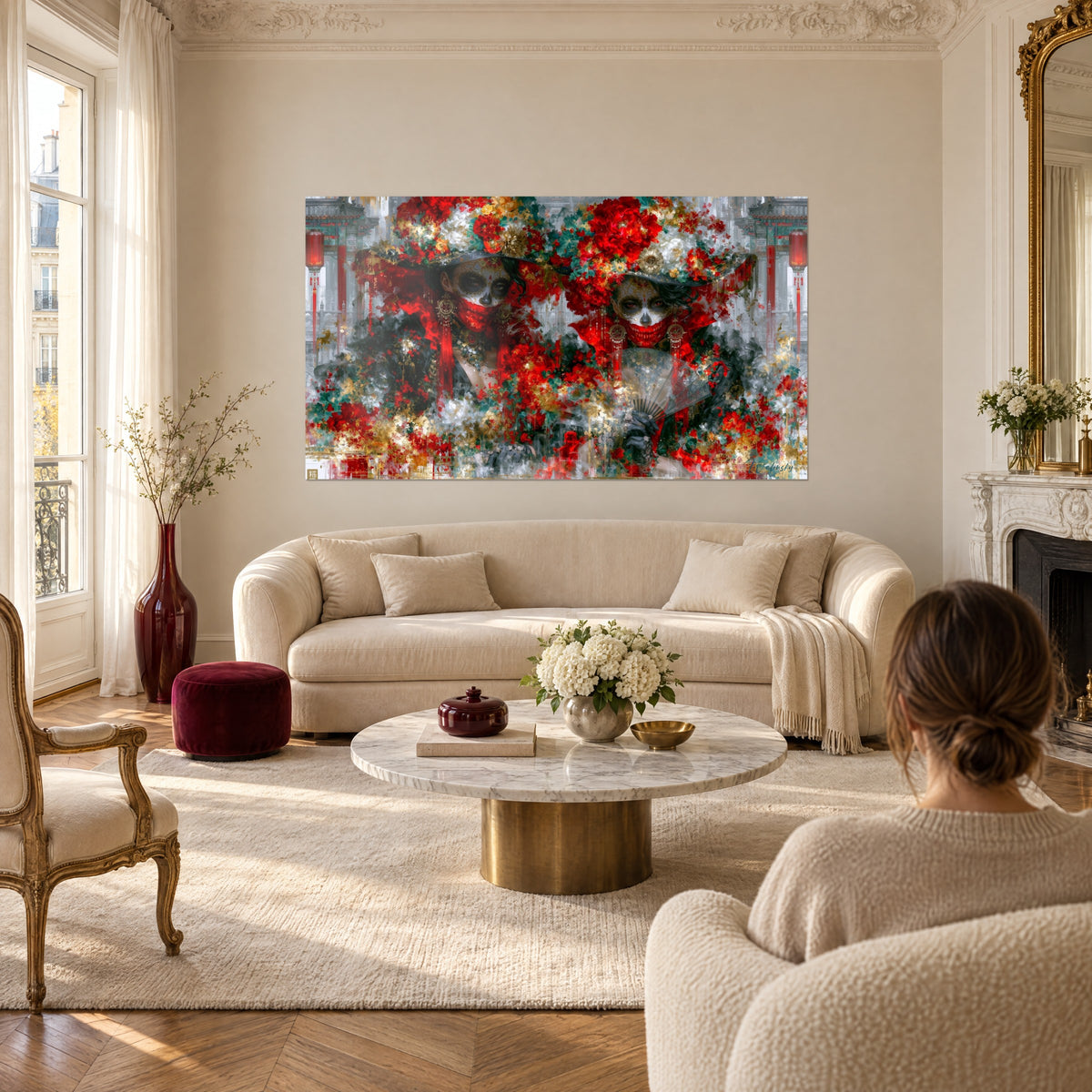 Gemälde zweier Gesichter als Calavera-Masken unter rot-grünen Blumenhüten, gefalteter Fächer, über einem Sofa in einem hellen Wohnzimmer