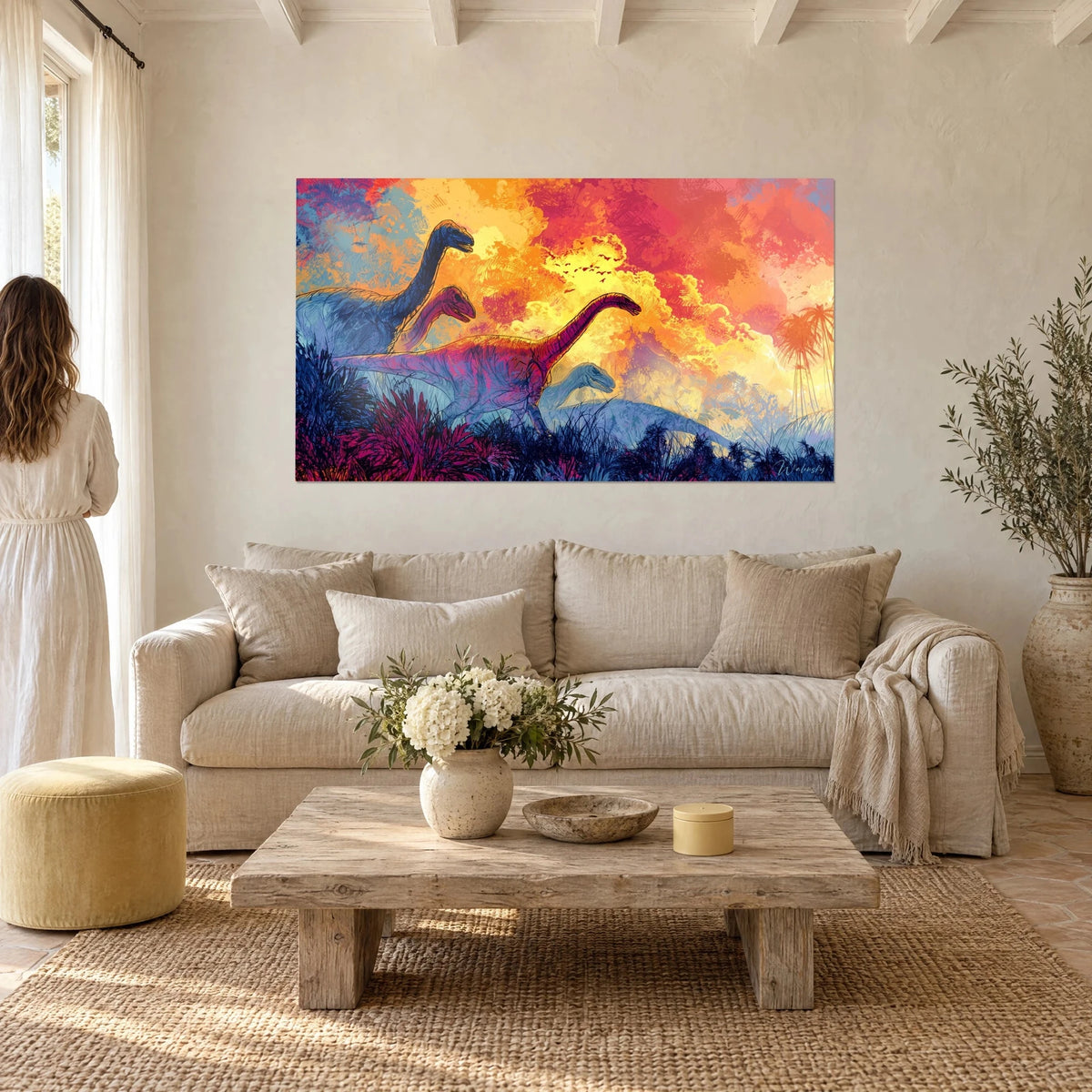 Gemälde Sauropoden mit langen Hälsen in Blau und Magenta unter einem orangegelben Himmel, über einem Sofa in einem hellen Wohnzimmer