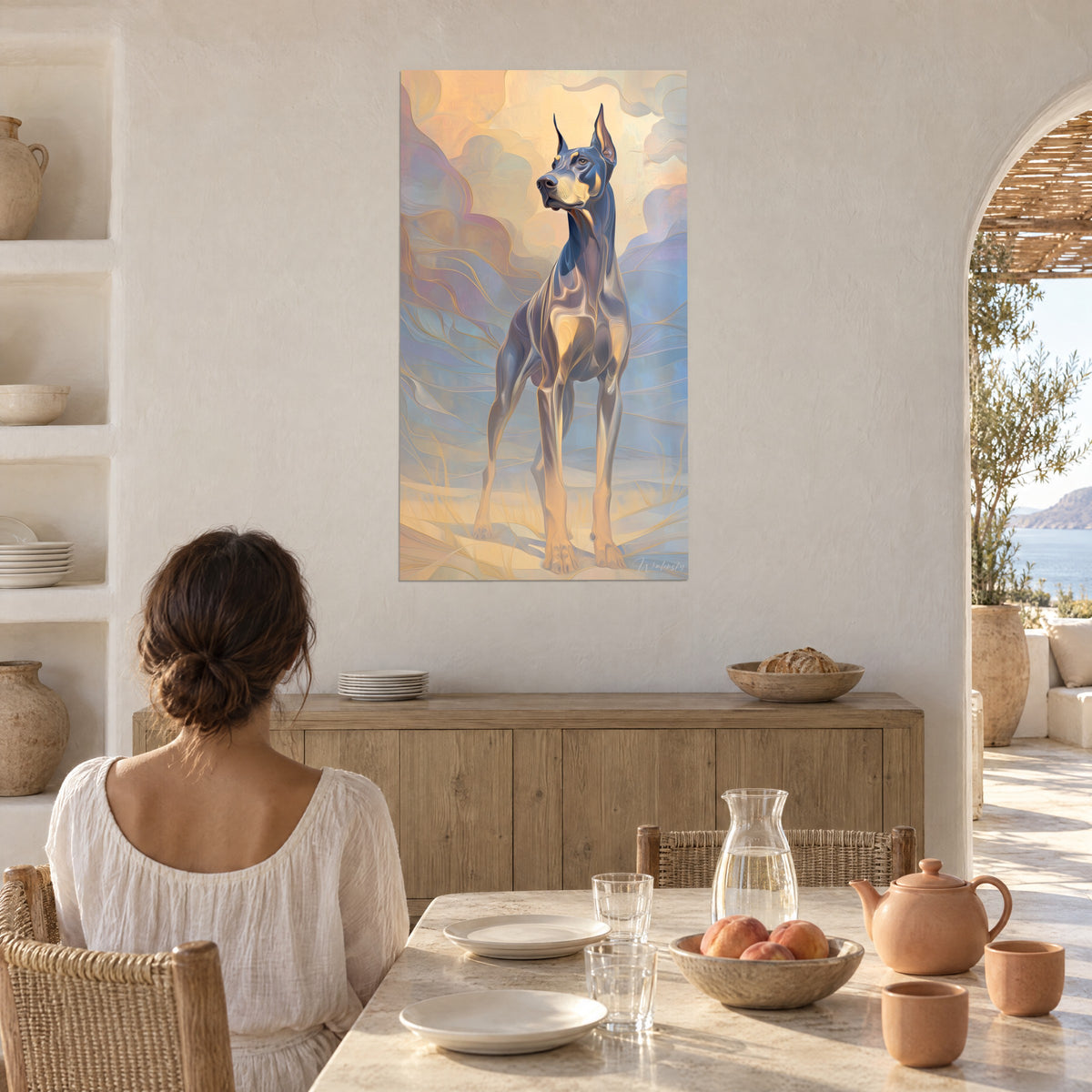 Schilderij statige dobermann-windhond, gouden wolken en poederblauw, jonge brunette vrouw van achteren aan een tafel voor een gewelfde stenen boog