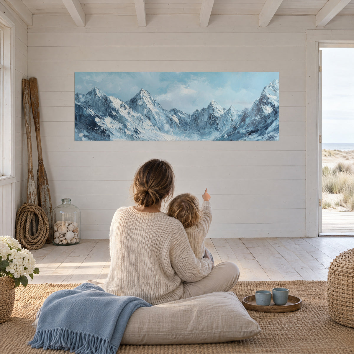 Cuadro Alpes nevados en amplias pinceladas con espátula de azul escarchado y blanco, una madre y su hijo de espaldas sobre un cojín de suelo
