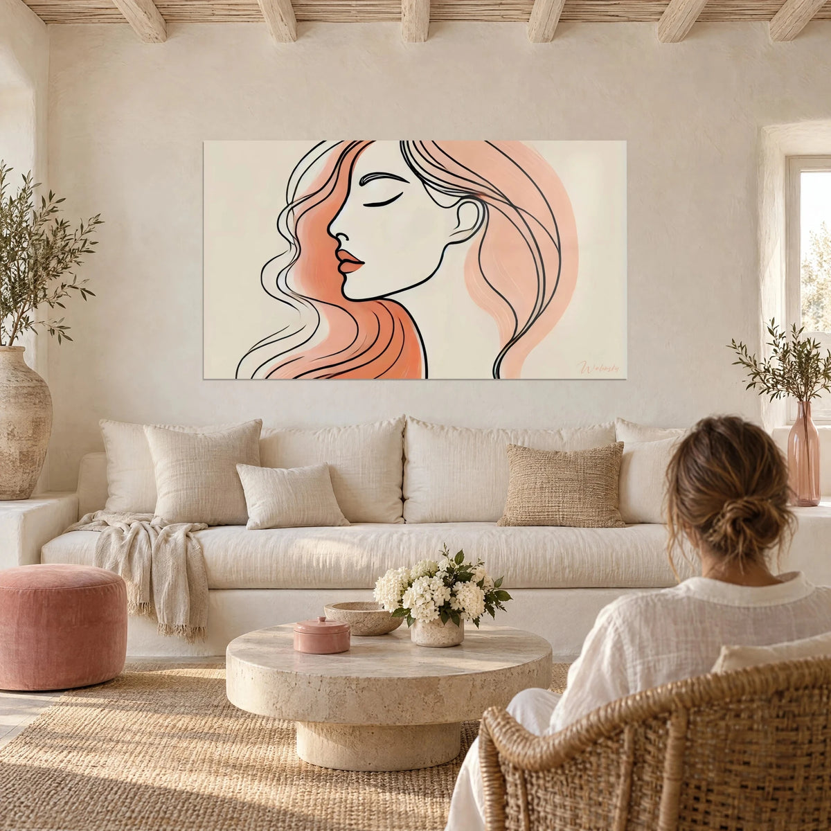 Tableau portrait féminin au trait noir, chevelure corail et rose pâle, au-dessus d'un canapé dans un salon lumineux