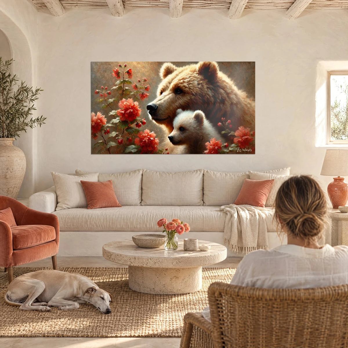 Tableau ourse brune et son ourson crème parmi des fleurs rouge corail, une femme et un lévrier, au-dessus d'un canapé dans un salon lumineux
