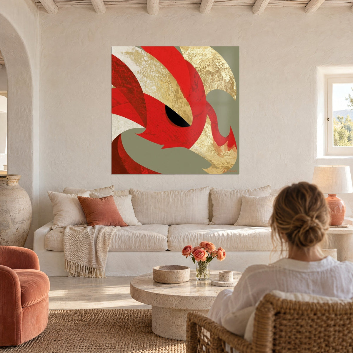 Tableau dragon rouge vermillon à l'œil noir, plumes d'or et fond vert sauge, au-dessus d'un canapé dans un salon lumineux