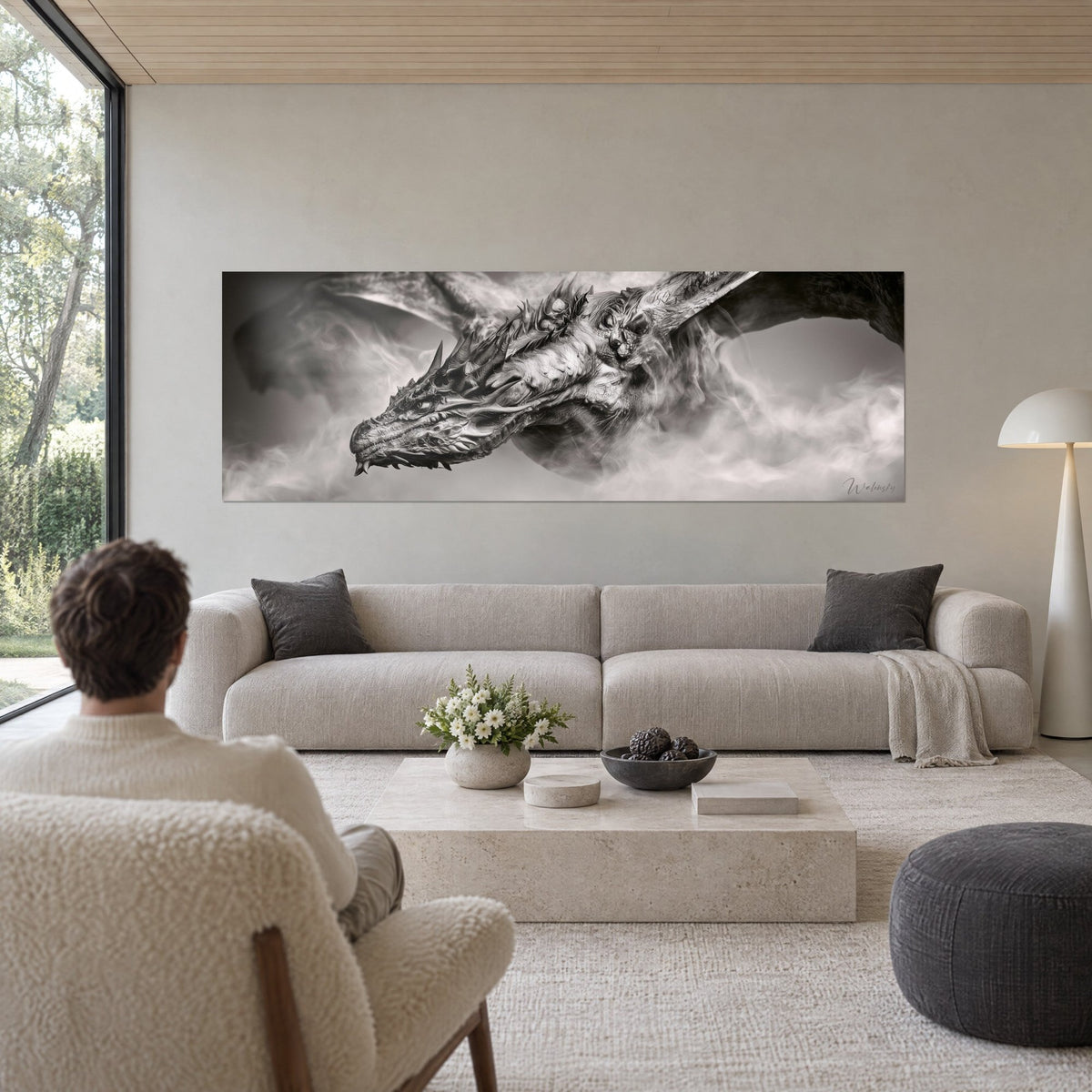 Quadro drago cornuto in bianco e nero, ali spiegate nella nebbia, un uomo di spalle, sopra un divano in un soggiorno luminoso
