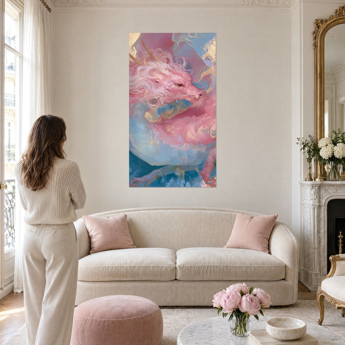 Cuadro dragón rosa enroscado de cuernos dorados y melena nacarada, mujer de espaldas, sobre un sofá en un salón luminoso