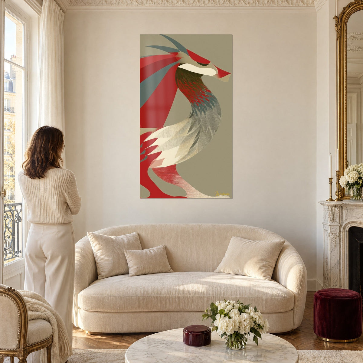 Tableau dragon rouge au cou sinueux, plumage gris et crème sur fond kaki, femme de dos, au-dessus d'un canapé dans un salon lumineux
