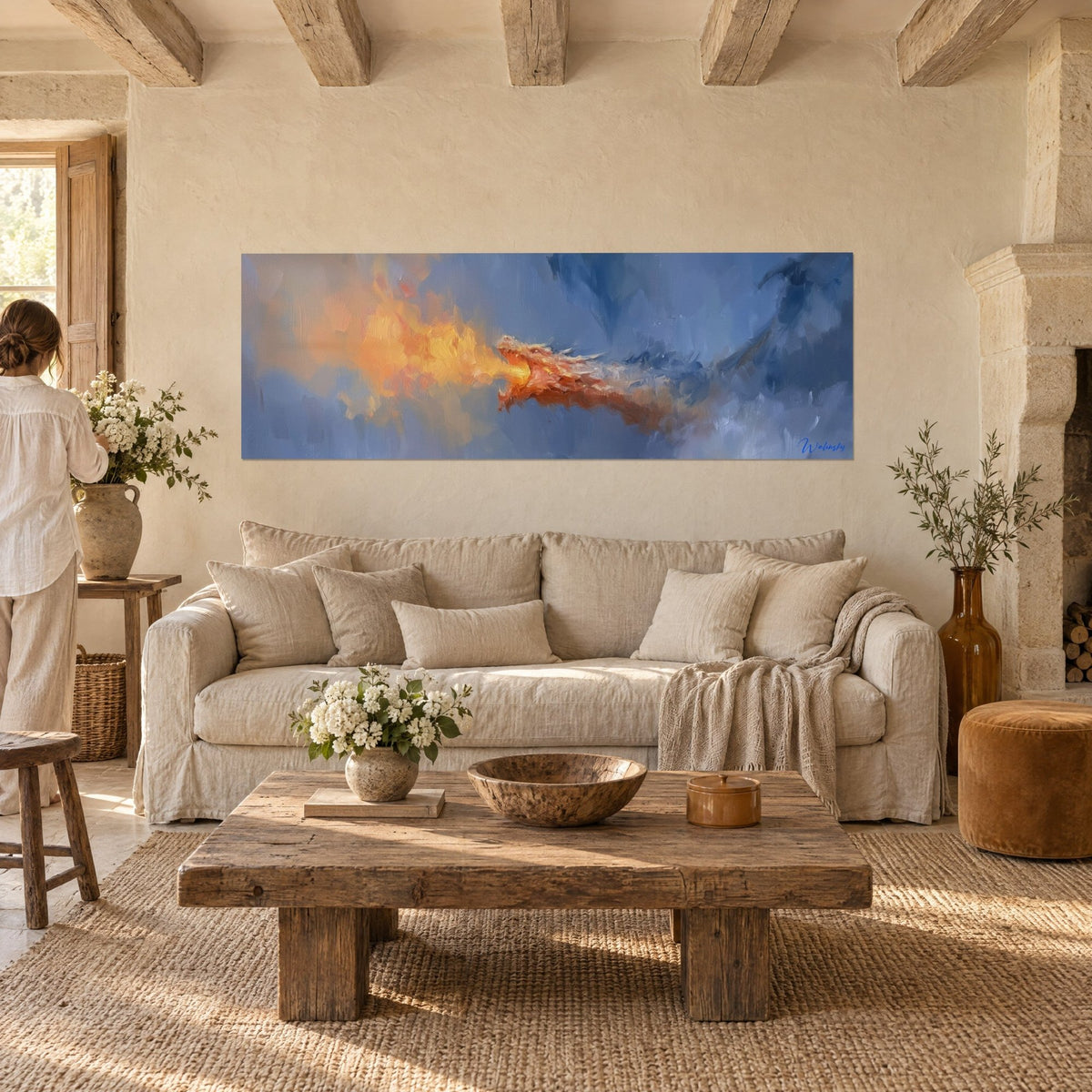 Gemälde eines rothaarigen Drachen, der eine orangefarbene Flamme vor nebelblauem Hintergrund speit, über einem Sofa in einem hellen Wohnzimmer