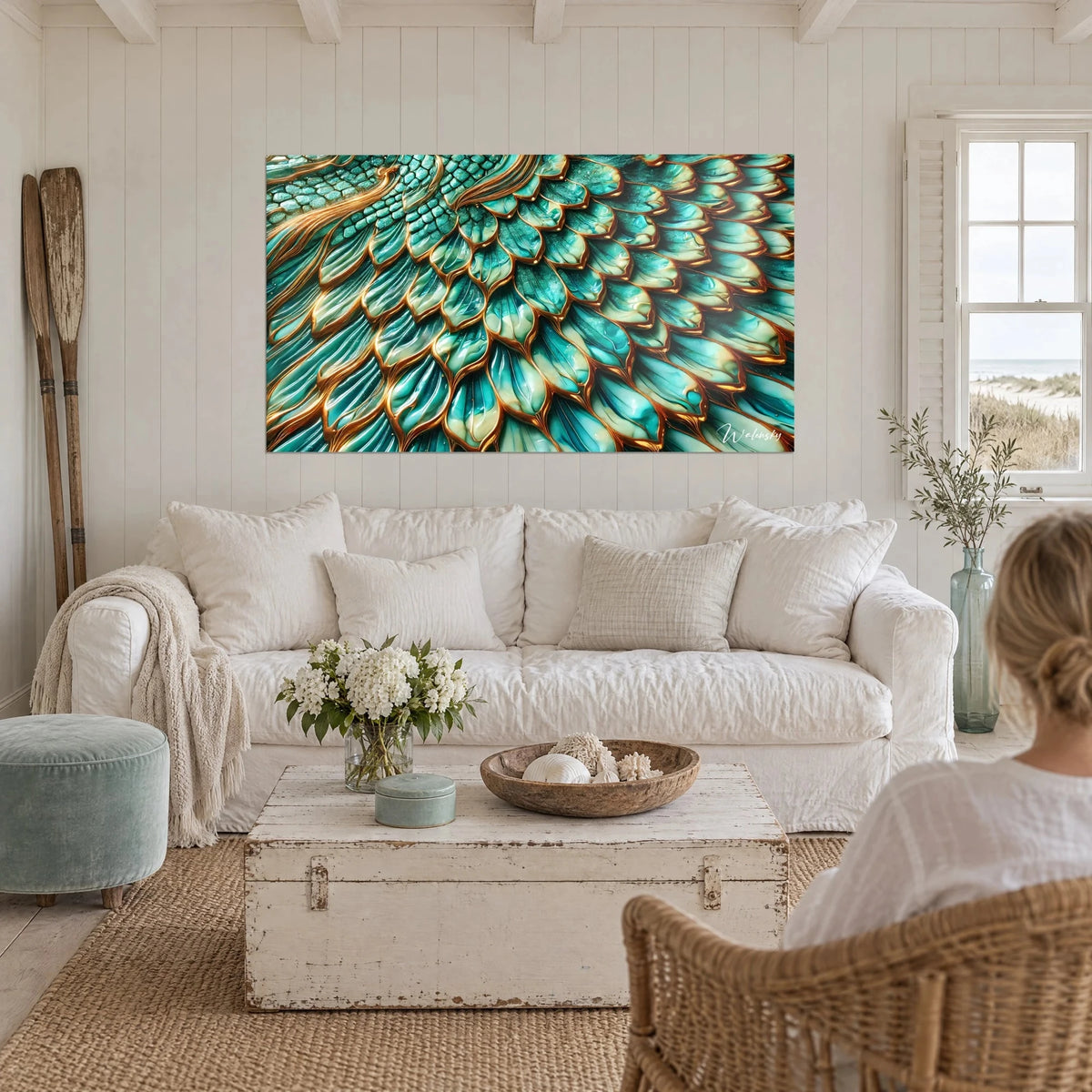 Tableau écailles émeraude et turquoise cernées de cuivre, une femme de dos le regarde au-dessus d'un canapé dans un salon lumineux