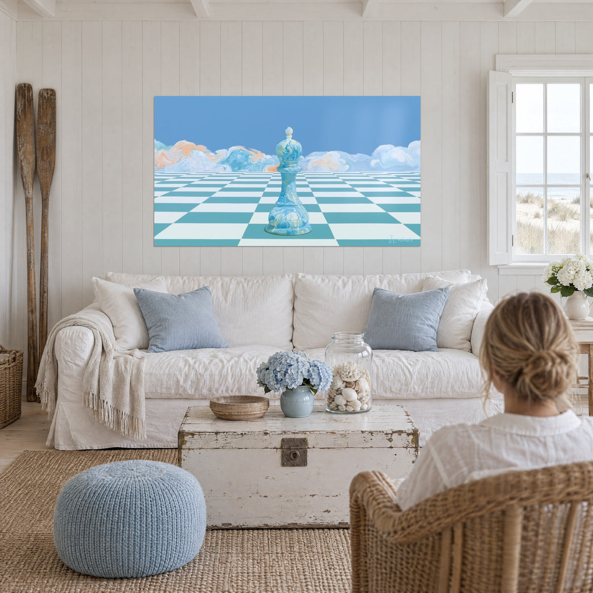 Quadro pedina degli scacchi marmorizzata azzurro cielo su scacchiera turchese e bianca, nuvole pesca, sopra un divano in un soggiorno luminoso