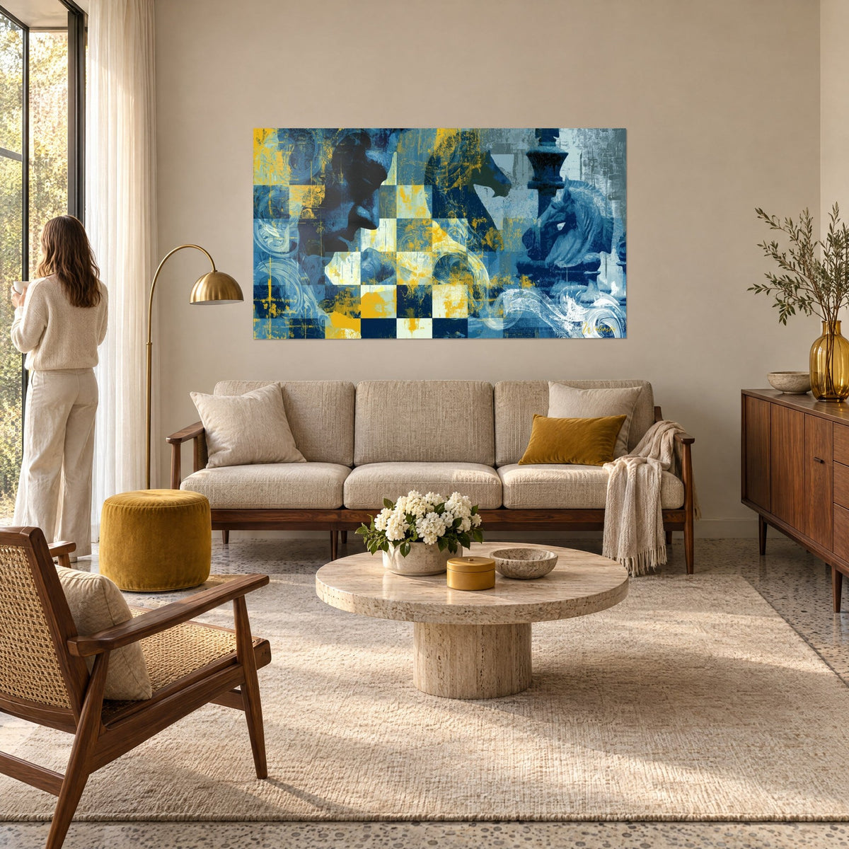 Quadro duello a scacchi in blu navy e giallo ocra, cavalli e alfieri su una scacchiera, donna di spalle, sopra un divano in un soggiorno luminoso