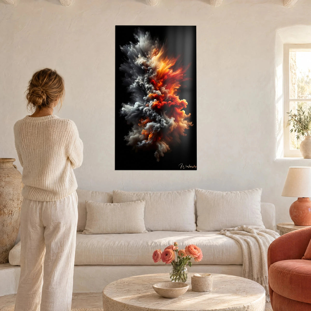 Quadro nuvola di fumo grigio e arancio su fondo nero, una donna di spalle lo contempla sopra un divano in un soggiorno luminoso