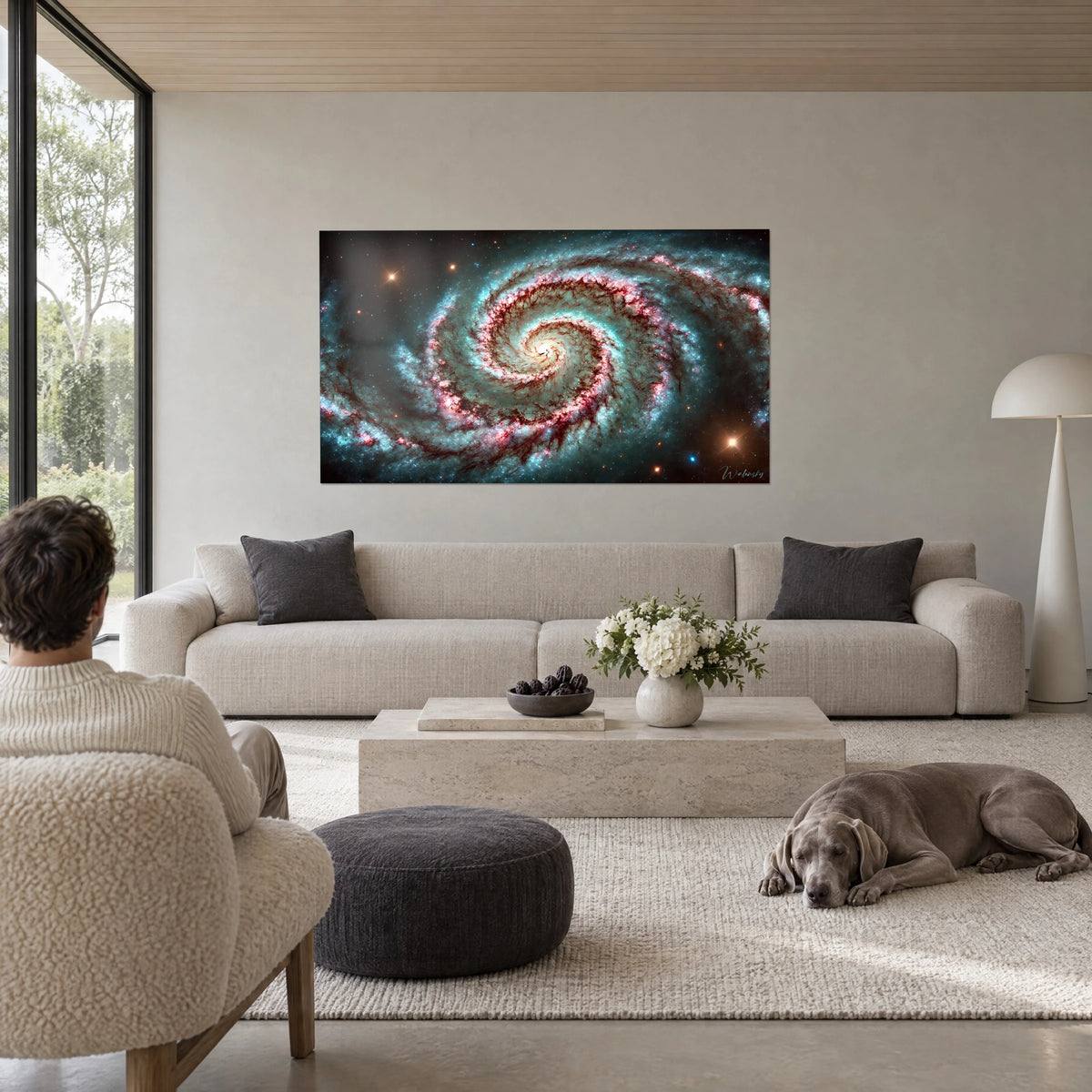 Wall art spiral galaxy with turquoise and bright pink arms, orange stars, above a sofa in a bright living room