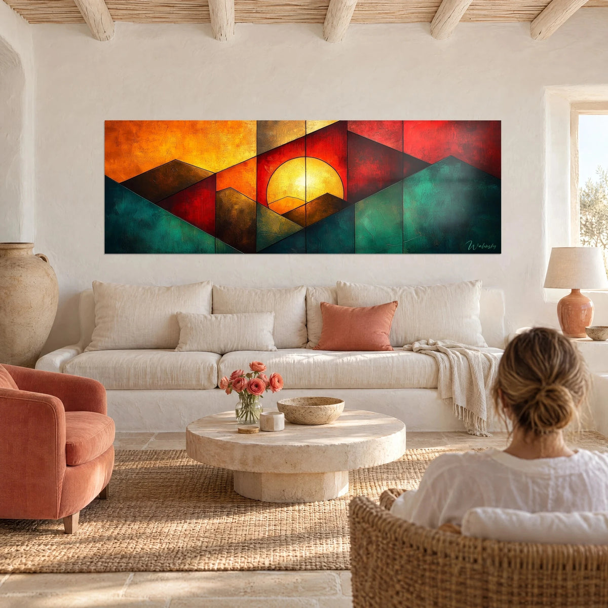 Wall art with a yellow sun ringed by red and emerald green diamonds, hanging above a sofa in a bright living room