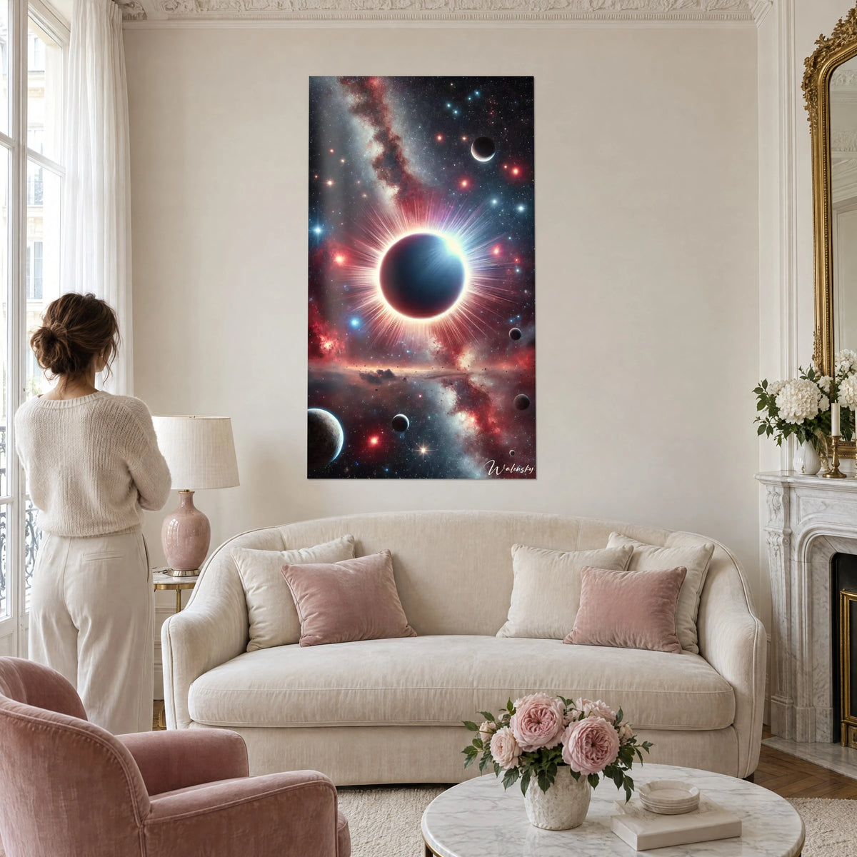 Schilderij zonsverduistering met roze en witte corona, sterrenhemel in rood en blauw, vrouw van achteren, boven een bank in een lichte woonkamer