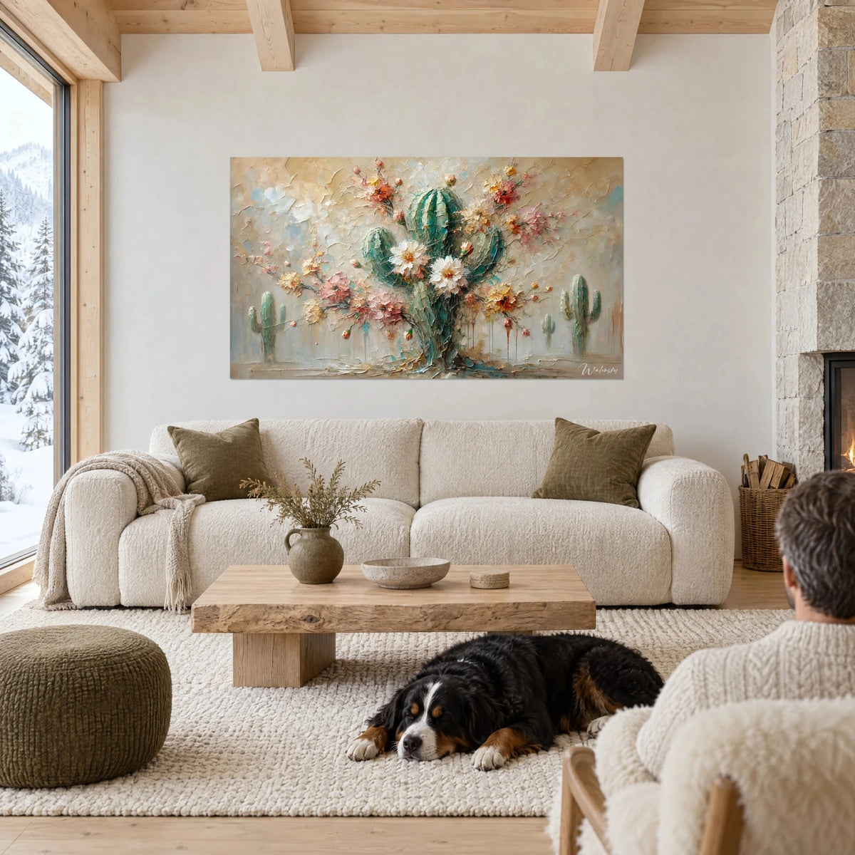 Wall art thick-textured blooming cactus, verdigris and powdery pink, a black dog sleeps above a sofa in a bright living room
