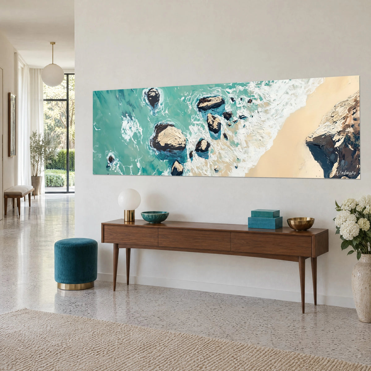 Schilderij kustlijn van bovenaf gezien, witte golven, turquoise water en beige zand, op een walnoten console in een lichte hal