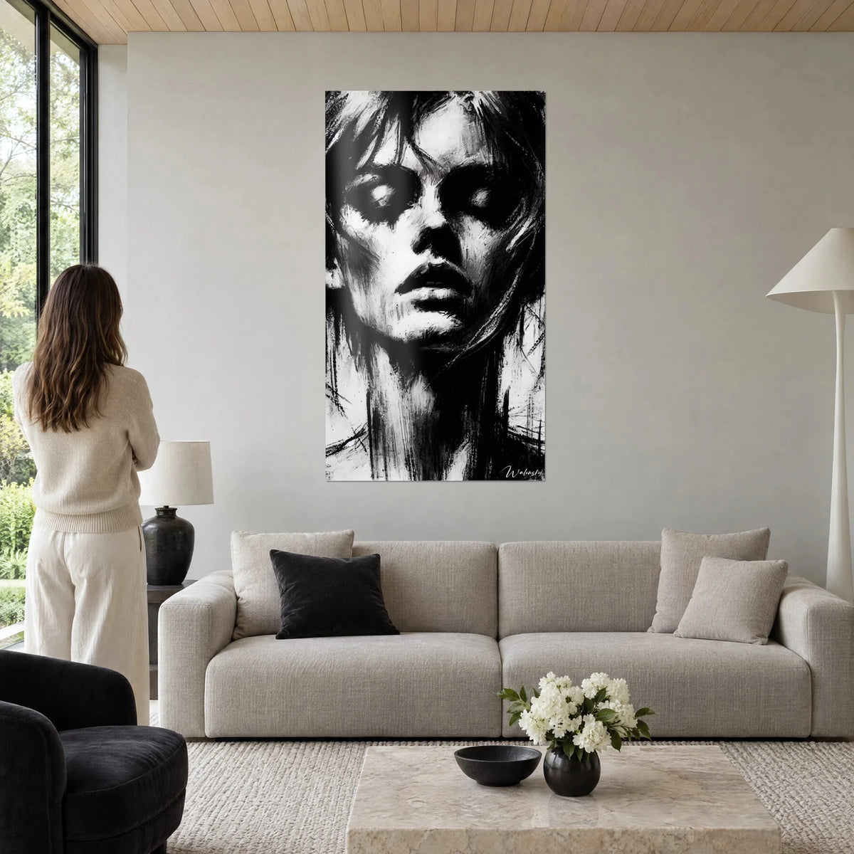 Schilderij vrouwenportret met gesloten oogleden, zwart-wit houtskool, losse uitgeveegde plukken, boven een bank in een lichte woonkamer