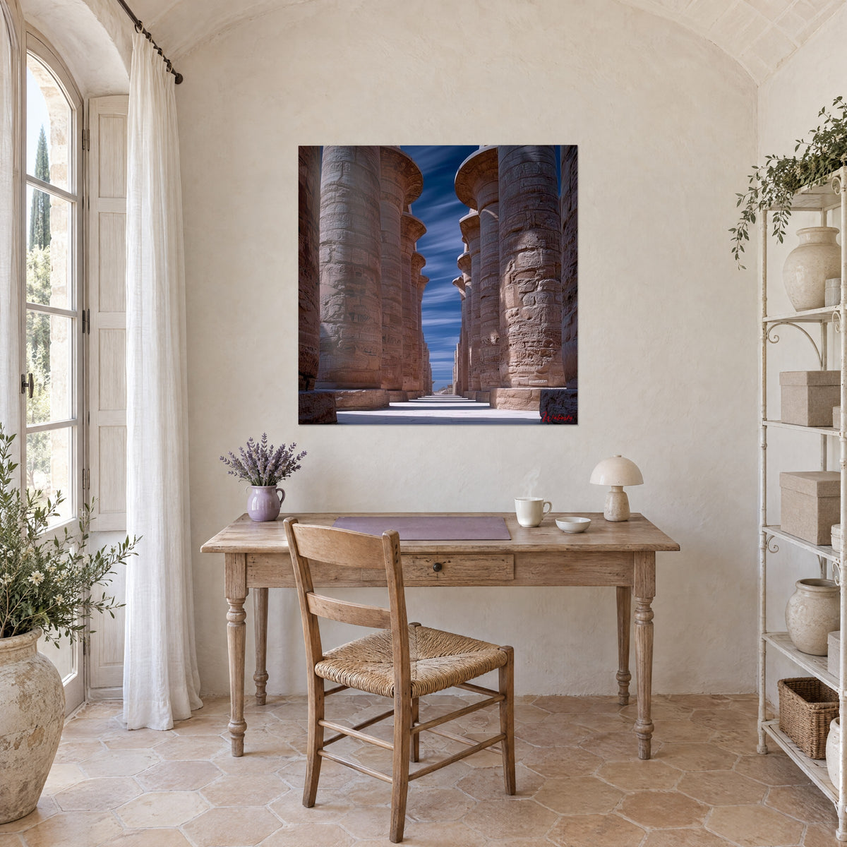 Tableau avenue d'immenses piliers égyptiens ocre rouille et azur profond, accroché au-dessus d'un bureau en bois clair près d'une fenêtre