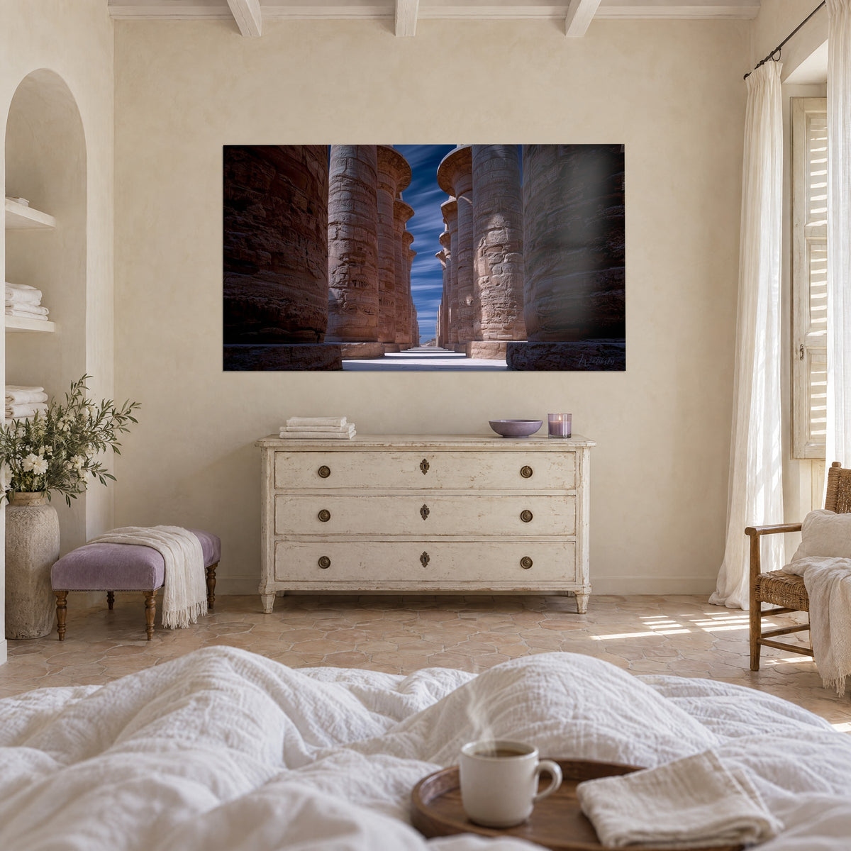 Schilderij hypostyle zaal in okerkleurig zandsteen en nachtblauwe lucht met wolkenstrepen, boven een bed in een lichte slaapkamer