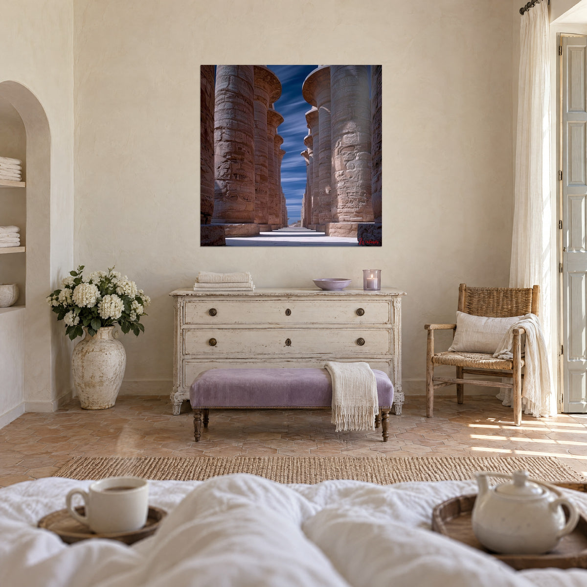 Tableau salle hypostyle aux fûts sculptés couleur sable, ciel bleu marine zébré de nuages, au-dessus d'un lit dans une chambre claire